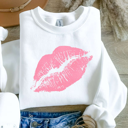 White sweatshirt with pink lipstick print on a wooden surface