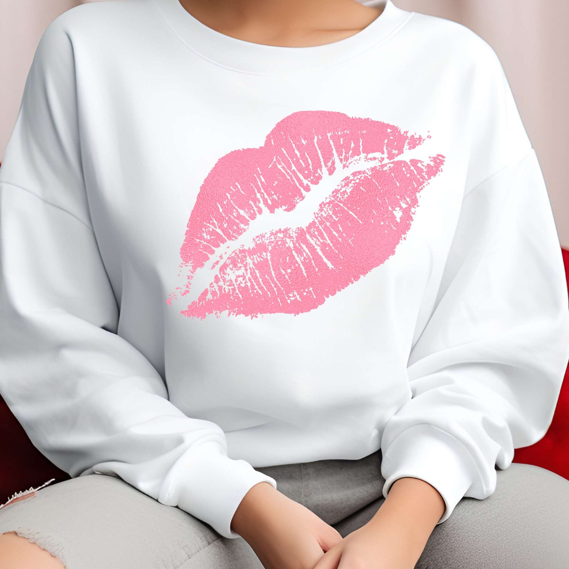 White sweatshirt with a pink lipstick print worn by a person.