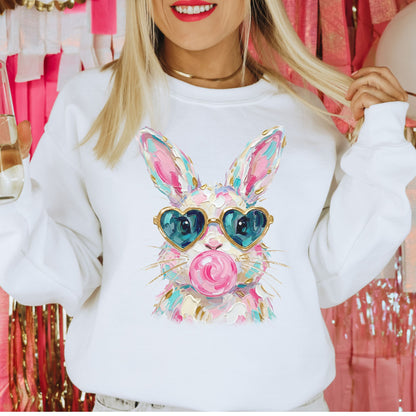 Person wearing a white sweatshirt with a colorful bunny design and sunglasses.