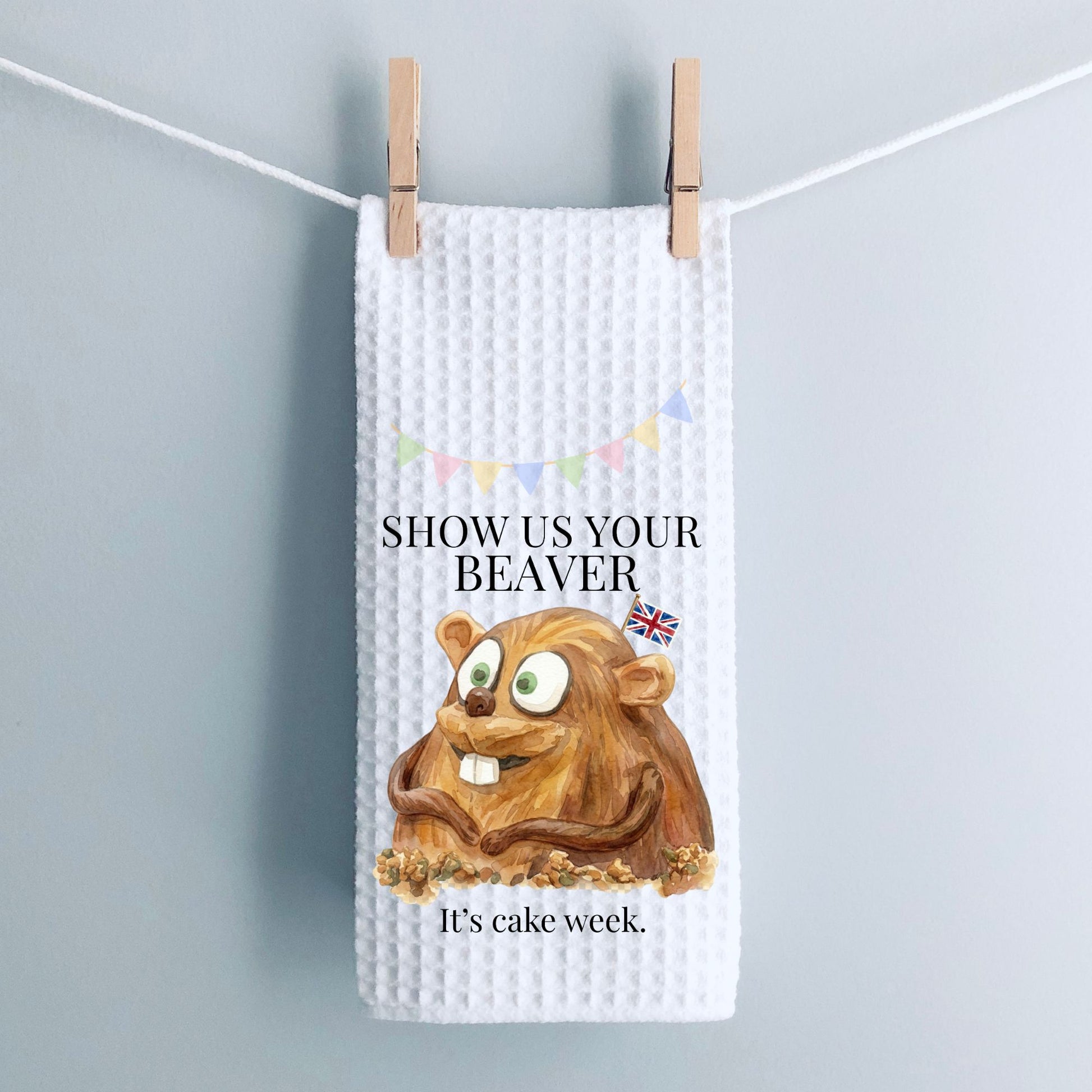 White waffle-textured towel with a cartoon beaver and text on a gray background
