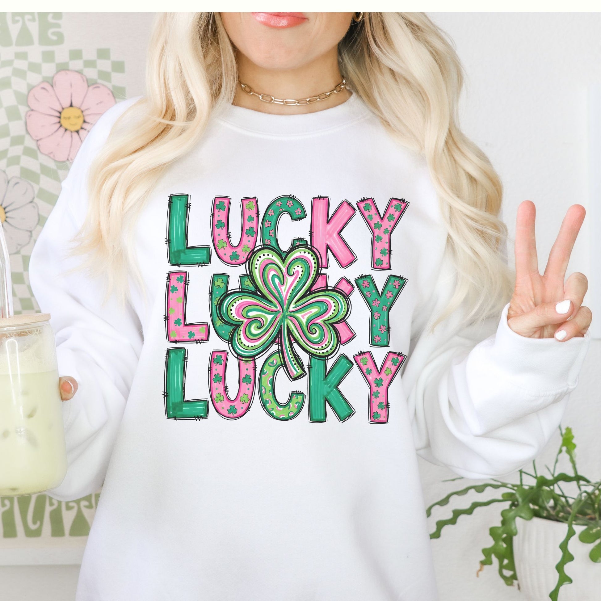 Person wearing a white St Patrick's Day crewneck sweatshirt with 'Lucky Lucky Lucky' text and a shamrock design.