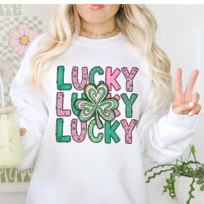 Person wearing a white St Patrick's Day crewneck sweatshirt with 'Lucky Lucky Lucky' text and a shamrock design.