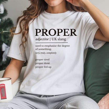 Person wearing a white t-shirt with the word 'PROPER' and its definition printed on it, sitting on a couch.