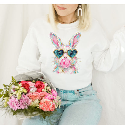 Person wearing a white sweatshirt with a colorful bunny design, holding a bouquet of flowers.