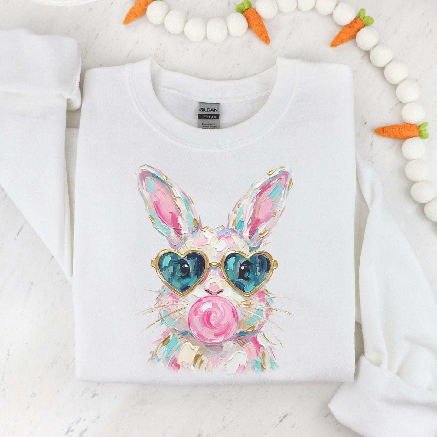 White sweatshirt with a colorful bunny design wearing heart-shaped sunglasses on a white background.