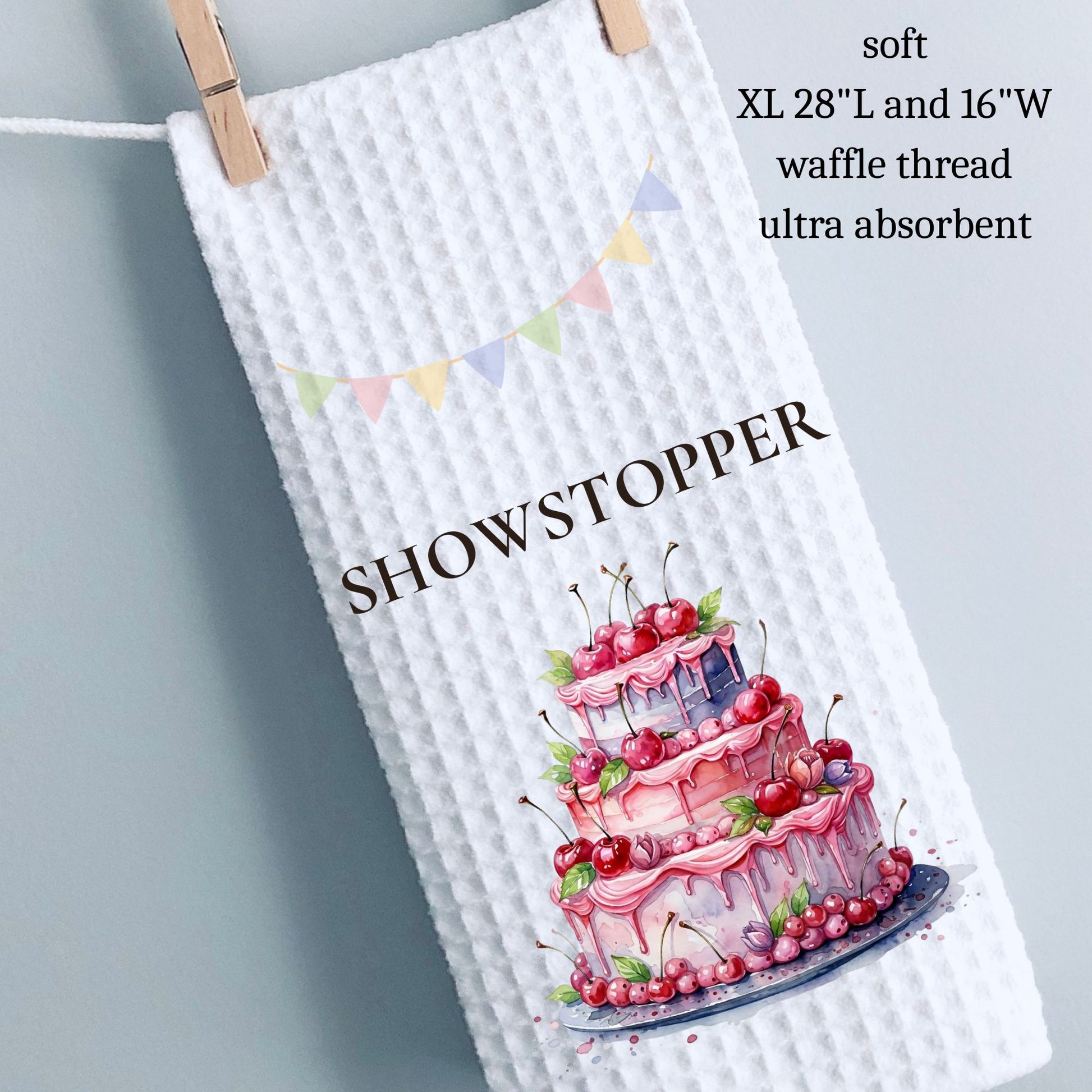 Waffle-textured towel with a cake illustration and 'Showstopper' text on a gray background